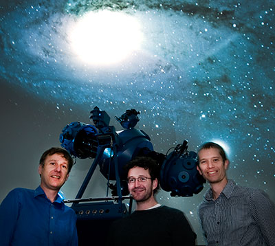astronomy researchers in front of telescope with 3.2-billion-pixel camera for detecting asteroids
