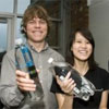 2 students hold up water bottles