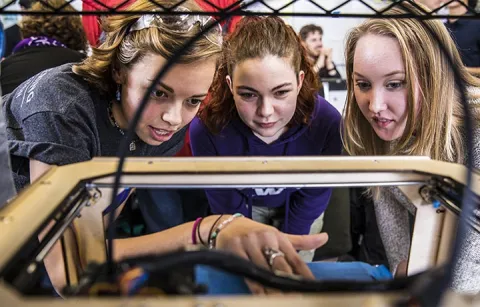 Sierra Simmerman, Ashley Piggott and Madison Johnson tweak one of the club’s 3D printers