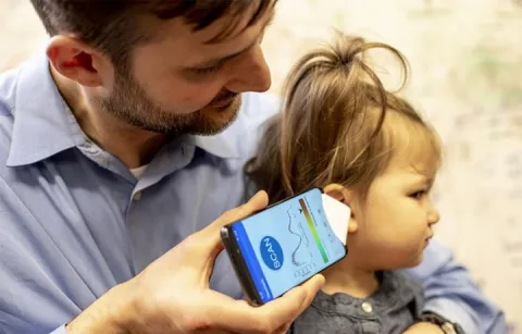 A doctor uses the app to check his daughter's ear