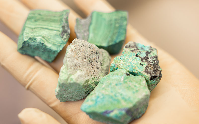 Rock-looking minerals coated in a green-turquoise tint.