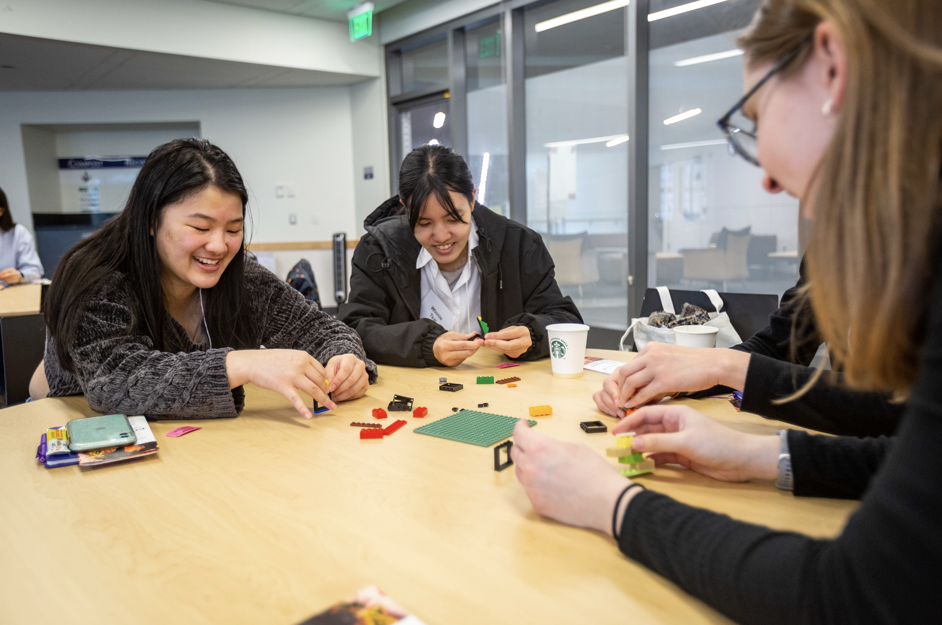 a group of people playing with legos on a table