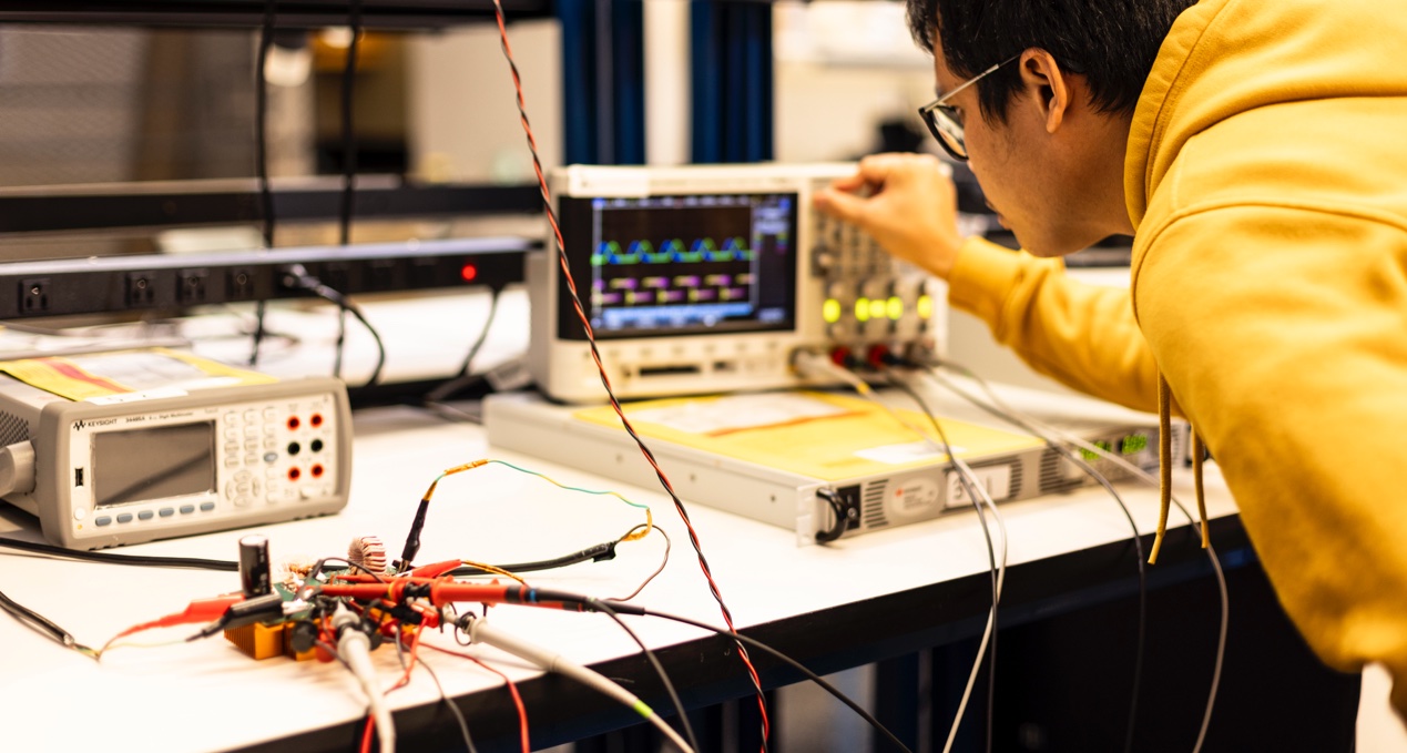 Student in a lab analyzing data on a screen from a circuit