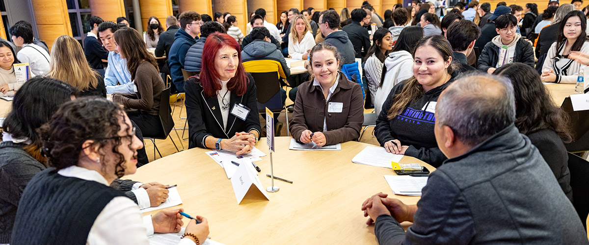 Students and alumni talking in group setting.