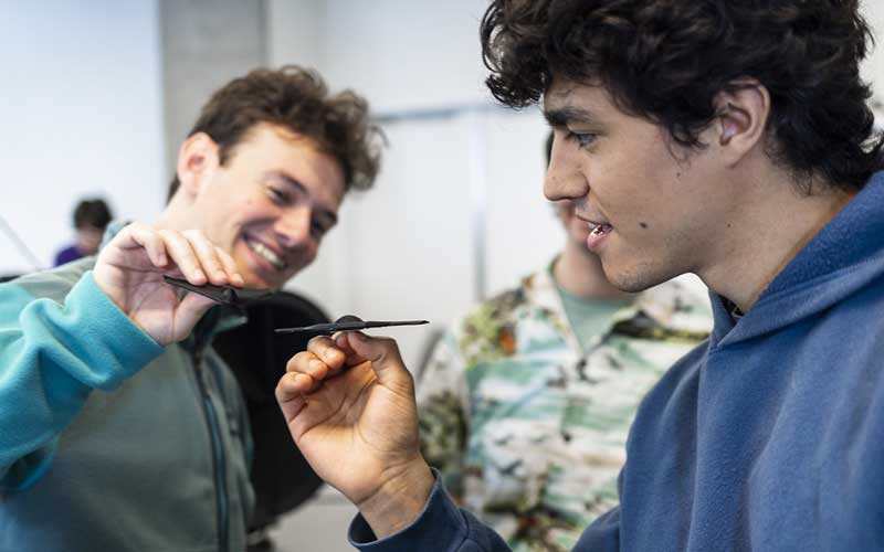 Two students experimenting with 3D printing wing structures in lab