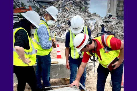 NIST and U.S. Army Corps of Engineers staff members inspect a building element from the Champlain Towers South partial collapse in Surfside, Florida, for its evidentiary potential.