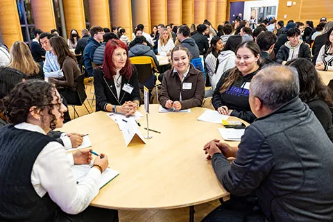 Alumni speaking to a group of students in a round-table setting.