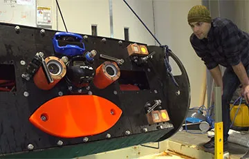 Paul Gibbs, a mechanical engineer at the UW’s Applied Physics Laboratory, inspects the newest Adaptable Monitoring Package, or AMP, before a test in a saltwater pool. 