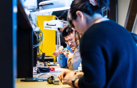 Two people looking closely at computing parts