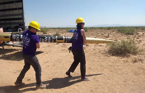 students carrying a rocket