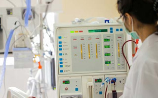 Student wearing lab coat working with medical equipment