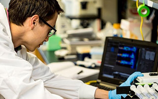 Student wearing protective gear using computer in lab