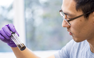 Student looking at vial with sample