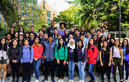 A group shot of students in front of a large Microsoft logo