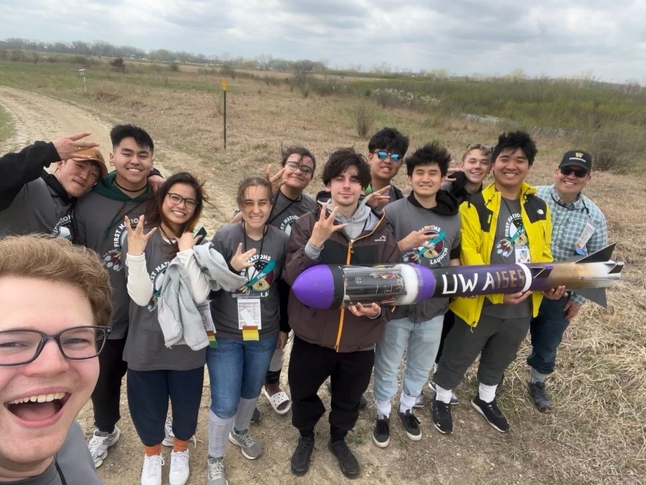 The AISES UW team standing outside in Wisconsin holding the recovered rocket after it successfully launched