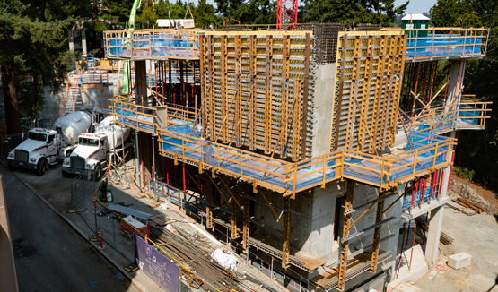 Construction site with partially built concrete structure and scaffolding.