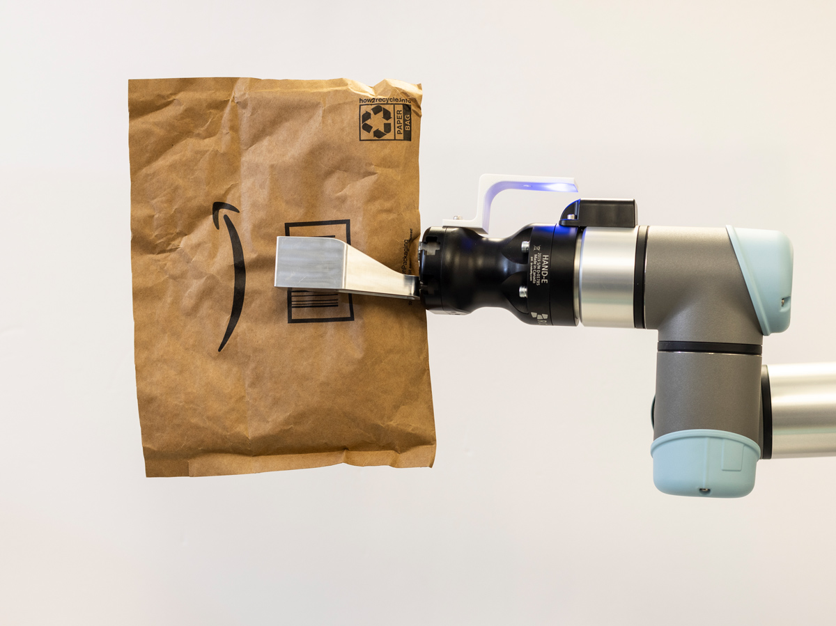 A robotic arm holding an Amazon package