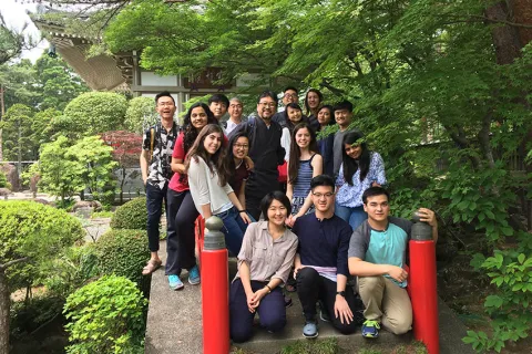 A group of students posing in front of a traditional Japanese building