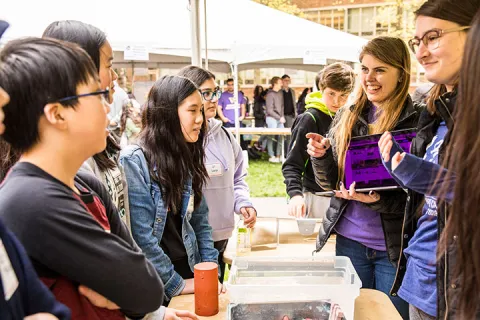 A UW student speaking with three k-12 students