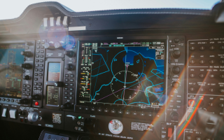 Cockpit dashboard featuring navigation screens and various control buttons and dials.