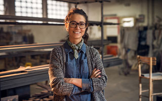Person smiling with crossed eyes standing in the middle of workshop-style setting